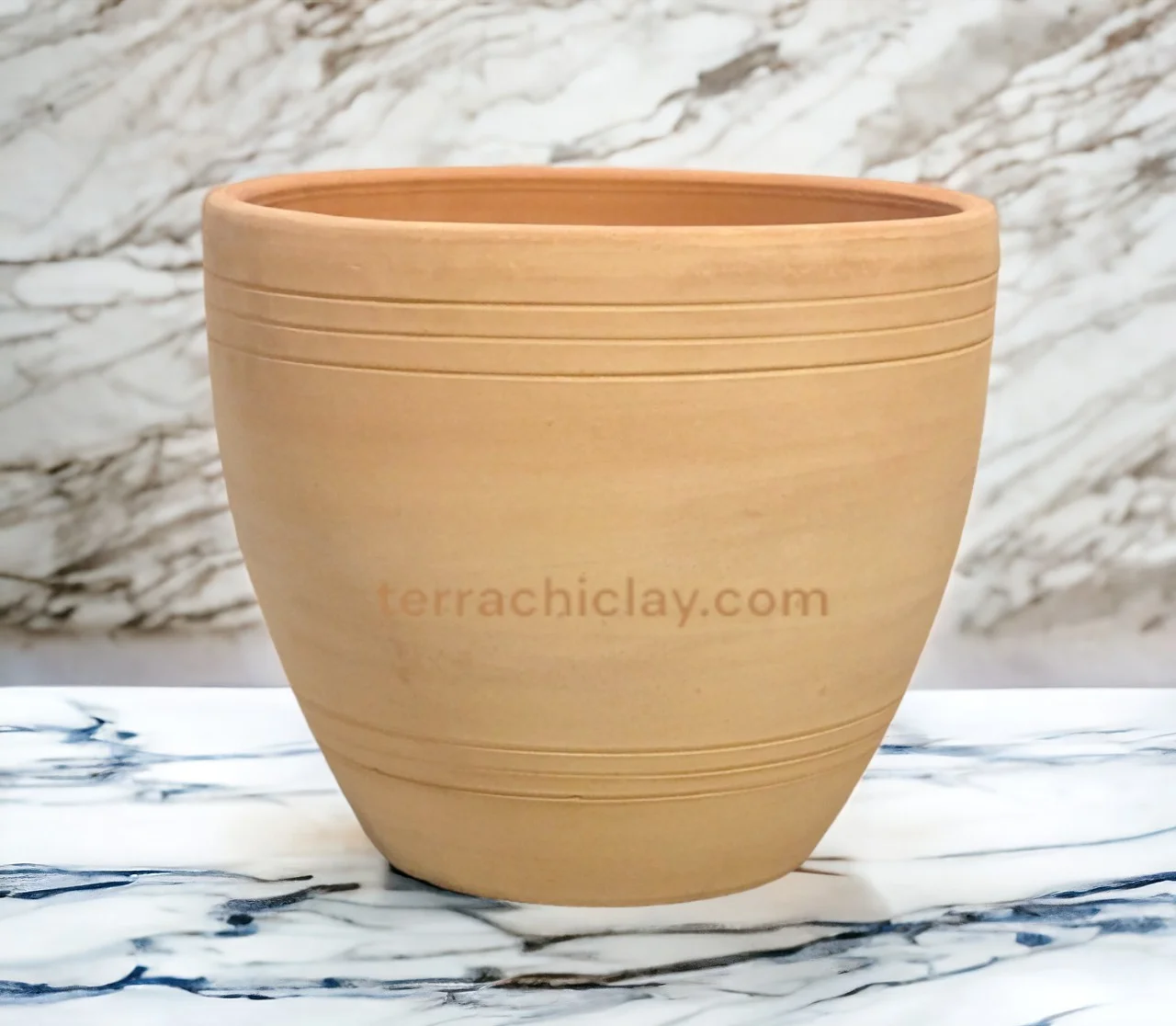 A large clay pot on a marble counter.