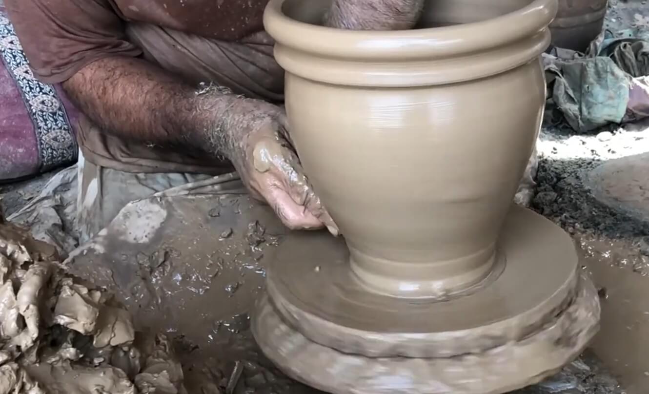 Artisan shaping terracotta pots on a traditional potter's wheel at Terrachi Clay