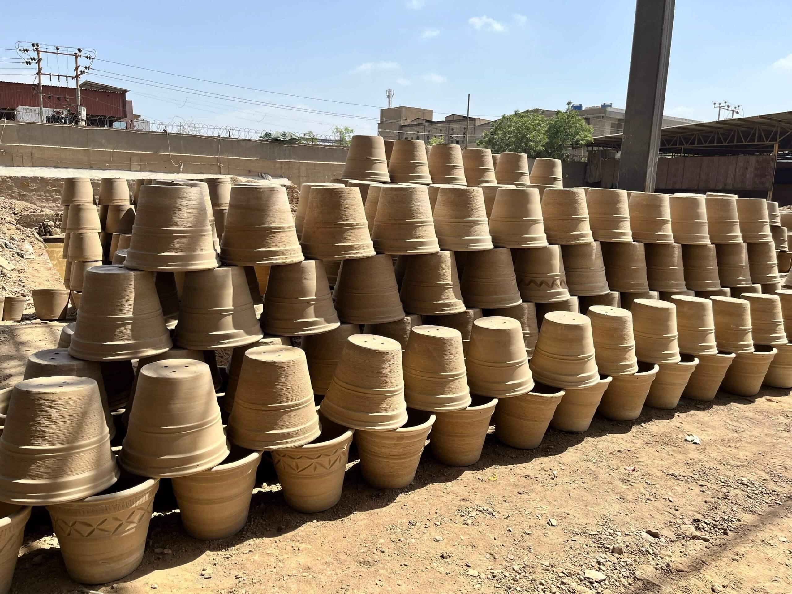Home 2 Rows of handmade terracotta pots drying in the sun at Terrachi Clay factory - wholesale terracotta manufacturer