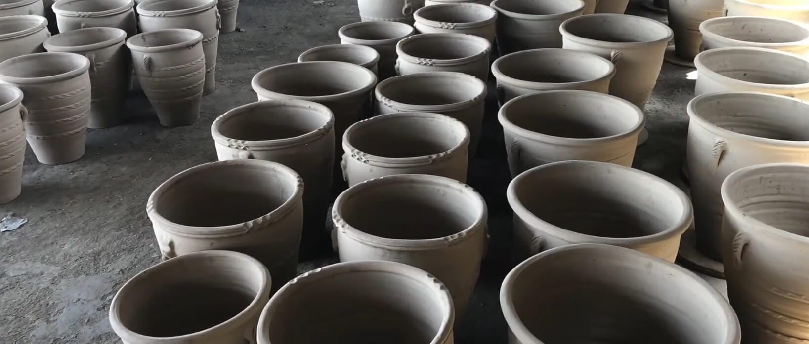 Handmade terracotta pots left to dry in natural sunlight